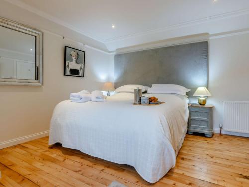 a bedroom with a large white bed and a wooden floor at 5 Bed in Anstruther 83504 in Pittenweem