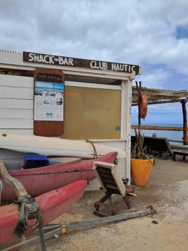 a shack on the beach with two boats and a chair at Vivenda Mia in Beirona