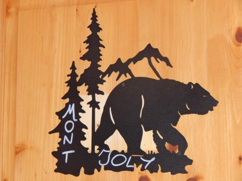 a wooden sign with a bear and trees at Chalet LE VAL NESS in La Côte dʼArbroz