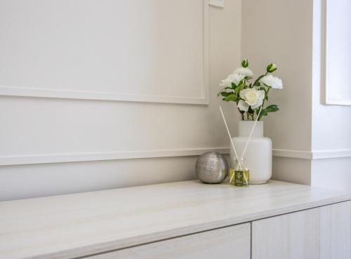 a vase of flowers on a counter in a room at Primeworld District Condo - Near Mactan Airport in Lapu Lapu City