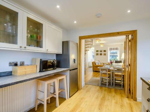 a kitchen and living room with a table and a microwave at 3 Bed in Lockerbie 89406 in Lockerbie