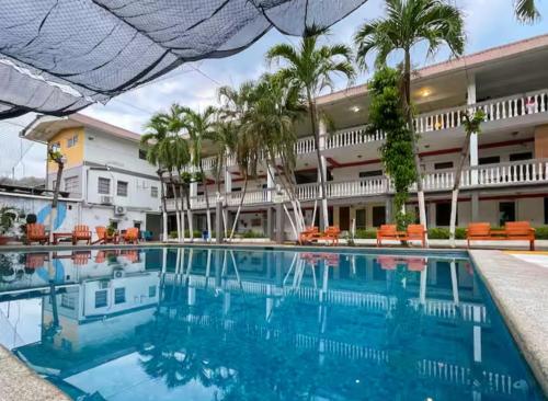 una piscina frente a un hotel con palmeras en Second Home on The Beach, en La Libertad