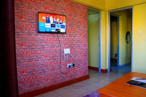 a wall with a tv on a brick wall at Kristina Homes in Voi