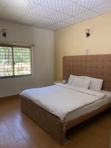 a bedroom with a large bed in a room at Pine Villa Cottage in Nārān