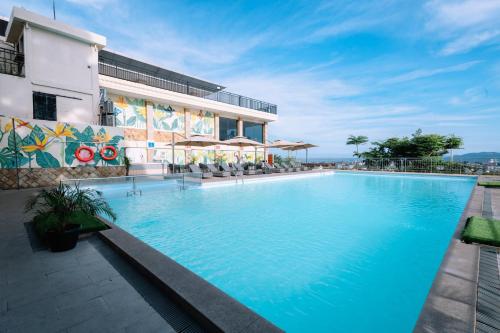 a large swimming pool in front of a building at Holiday Inn Lampung Bukit Randu by IHG in Bandar Lampung