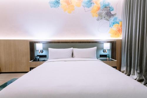 a bedroom with a large white bed in a room at Holiday Inn Lampung Bukit Randu by IHG in Bandar Lampung