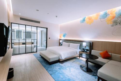 a hotel room with a bed and a couch at Holiday Inn Lampung Bukit Randu by IHG in Bandar Lampung