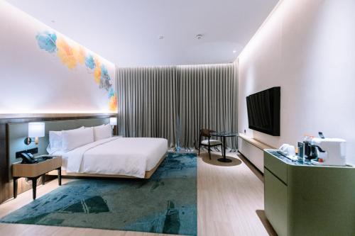 a hotel room with a bed and a television at Holiday Inn Lampung Bukit Randu by IHG in Bandar Lampung