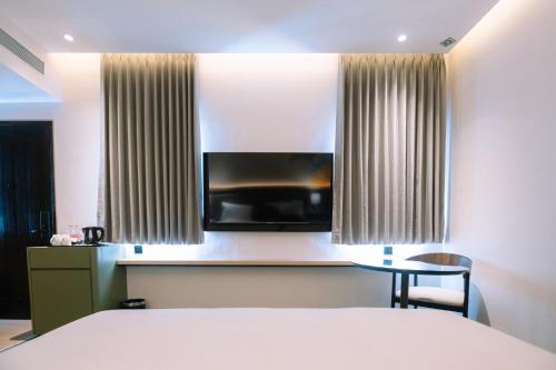 a hotel room with a bed and a table and a television at Holiday Inn Lampung Bukit Randu by IHG in Bandar Lampung