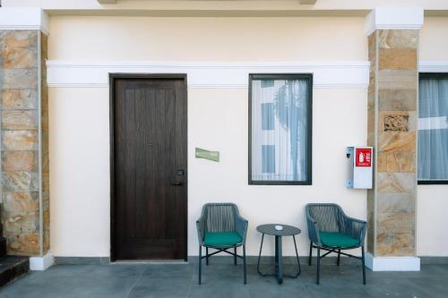 two chairs and a table next to a door at Holiday Inn Lampung Bukit Randu by IHG in Bandar Lampung