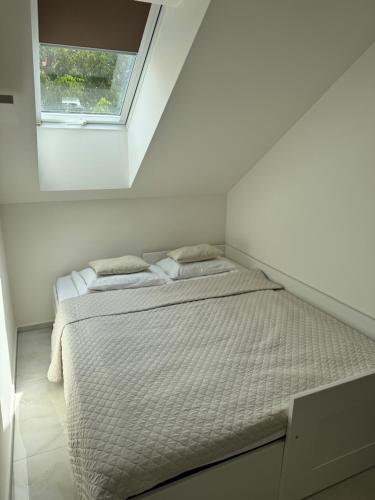a bed in a white room with a window at Apartmany u Polanských Lednice in Lednice