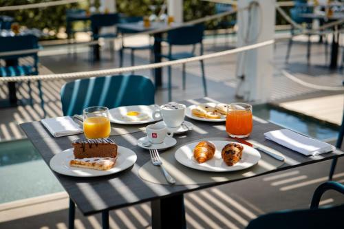 a table with breakfast food and drinks on a balcony at Resort La Battigia Beach & Spa in Alcamo Marina