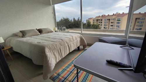 a bedroom with a bed and a table and a window at Oceana Suites Santo Domingo in Santo Domingo
