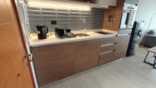 a kitchen with a sink and a refrigerator at Oceana Suites Santo Domingo in Santo Domingo