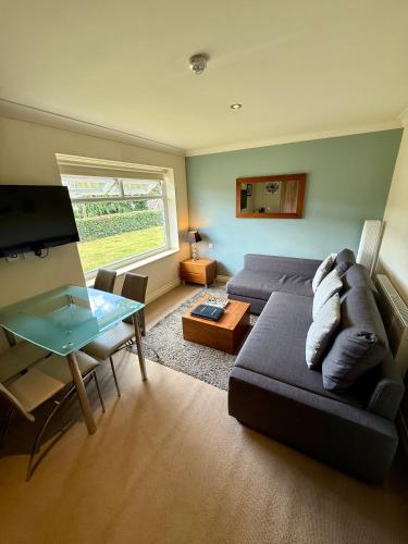 a living room with a couch and a table at Bagshaw Lodge in Bakewell