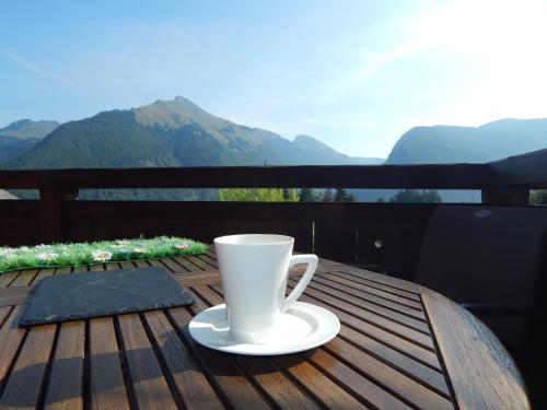a coffee cup sitting on top of a wooden table at Chalet LE VAL NESS in La Côte dʼArbroz