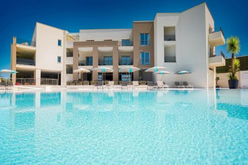 a swimming pool in front of a hotel at Resort La Battigia Beach & Spa in Alcamo Marina
