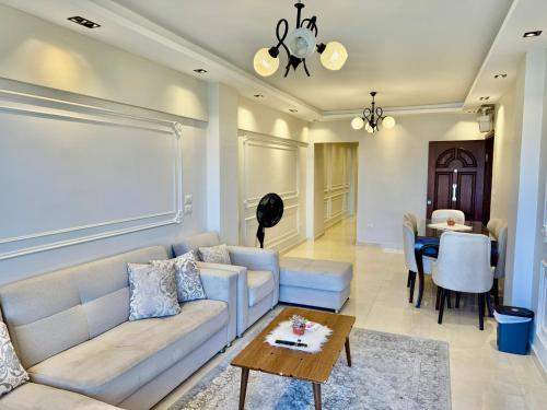 a living room with a couch and a table at ALEX HOMES - Gleem Luxury Apartments with Direct Sea View in Alexandria