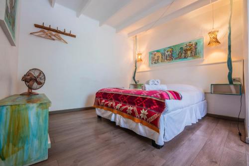 a bedroom with a bed with a red blanket at Hostal Copart in San Pedro de Atacama