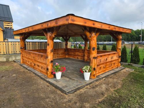 a wooden gazebo with two potted plants at Willa pod Smrekiem in Białka Tatrzanska