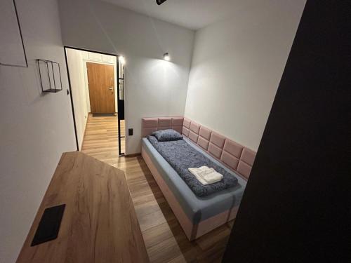 a small room with a bed and a table at Loft & City MANUFAKTURA in Łódź