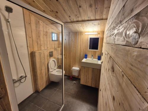a wooden bathroom with a toilet and a sink at Faraya Vista in Kfardebian