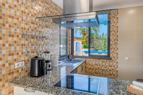 a kitchen with a sink and a window at Villa Ruana - 5 bedrooms on Suite- Free out door Hot Jacuzzi - By Bedzy in Albufeira