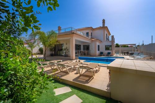 a villa with a swimming pool and a house at Villa Ruana - 5 bedrooms on Suite- Free out door Hot Jacuzzi - By Bedzy in Albufeira