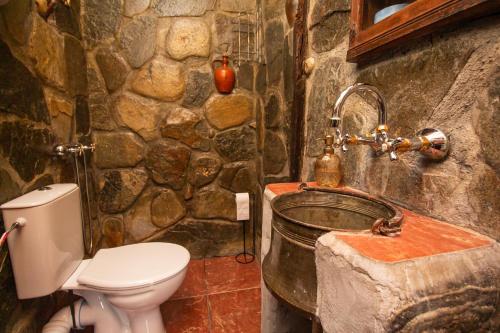 a stone bathroom with a toilet and a sink at Дедовата Къща in Dedovo