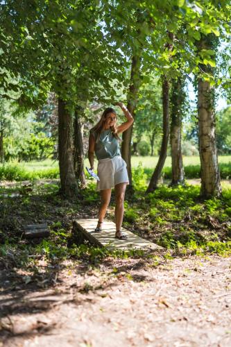 a woman standing on a board in a park at Le Domaine de Richebourg - Pierres d'Histoire in Richebourg