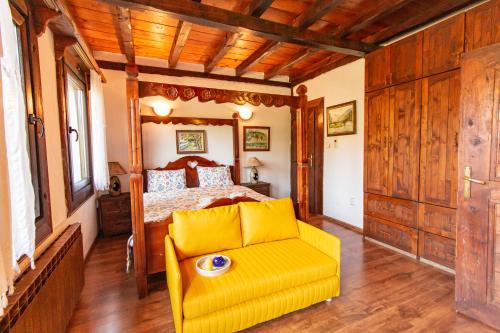 a bedroom with a bed and a yellow chair at Дедовата Къща in Dedovo