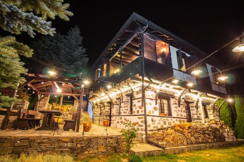a stone house with lights on it at night at Дедовата Къща in Dedovo