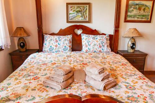 a bedroom with a bed with two towels and two lamps at Дедовата Къща in Dedovo