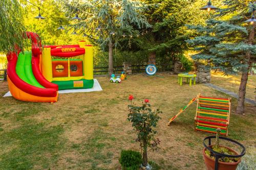 a playground with a slide in a yard at Дедовата Къща in Dedovo