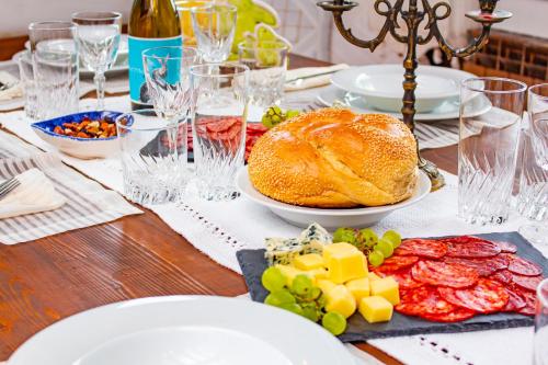 a table topped with plates of food and cheese at Дедовата Къща in Dedovo