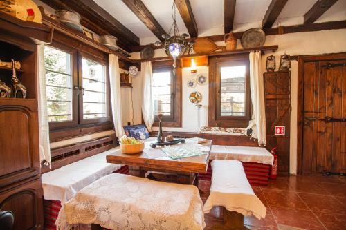 a room with two beds and a table and windows at Дедовата Къща in Dedovo