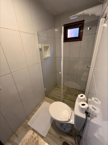 a small bathroom with a toilet and a television at Pousada Terra das Águas Barreirinhas in Barreirinhas