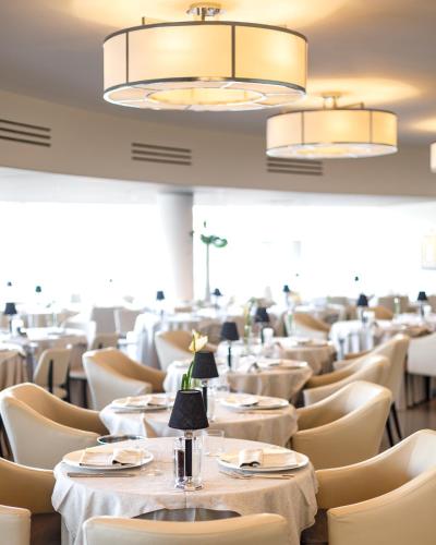 a dining room with white tables and chairs at Hotel Mariver in Lido di Jesolo