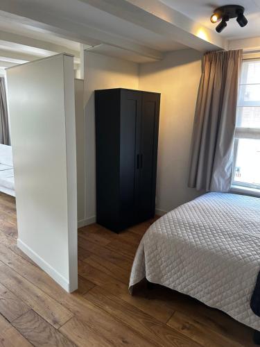 een slaapkamer met een bed en een zwarte kast bij Boutique Geldersekade in Amsterdam