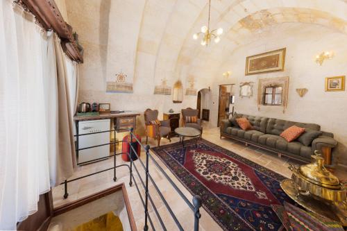 a living room with a couch and a table at Tafoni Houses Cave Hotel in Ortahisar