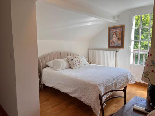 a bedroom with a bed with white sheets and pillows at Domaine en Sologne Piscine chambre Climatisée in Nouan-le-Fuzelier