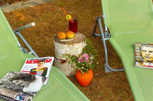 a green tent with a magazine and a plate of food at Дедовата Къща in Dedovo