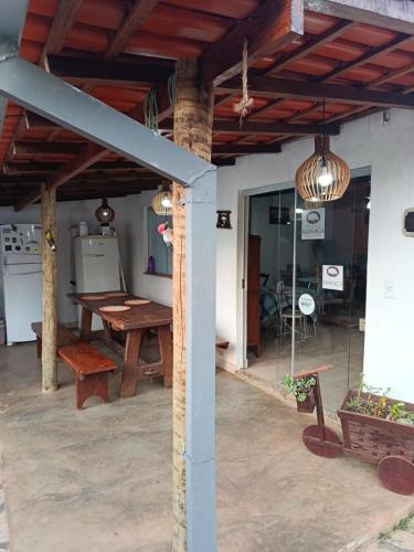 a patio with a wooden table and a wooden ceiling at POUSADA MANACÁ DA SERRA in Vargem Bonita