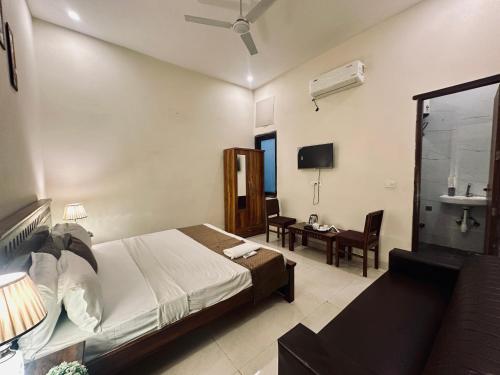 a bedroom with a bed and a desk and a chair at The White Scent-Near Noida Sector34 Metro in Noida