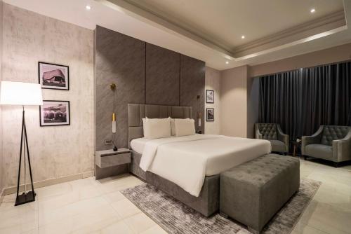 a bedroom with a large white bed and a chair at George Residence TLC in Lekki