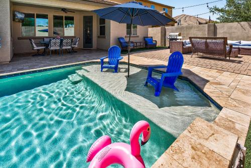 a swimming pool with two chairs and an umbrella at The Revel House in Phoenix