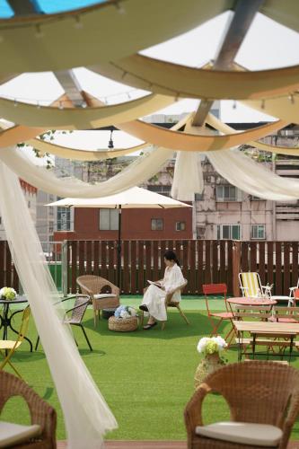 a woman sitting in a chair under a tent at D A L Premium Capsule Hotel in Seoul