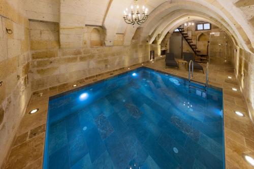 a swimming pool in a building with a ceiling at Tafoni Houses Cave Hotel in Ortahisar