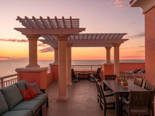 a patio with a couch and a table on a balcony at Hyatt Regency Clearwater Beach Resort & Spa in Clearwater Beach