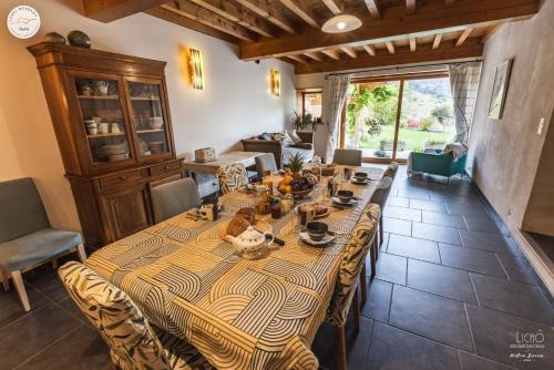 une salle à manger avec une grande table dans une pièce dans l'établissement Gîte et chambres d'hôtes "La Tourtette" 12 pers, à Saint-Étienne-en-Dévoluy